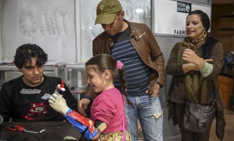 Colombian Shaio Valeria Novas, 6, tries her 3D printed prosthesis with a superhero “Wonder Woman” design, in Bogota, Colombia on June 12, 2017.  Fabrilab is a non-profit organization which develops free personalized prostheses with superhero designs, for disadvantaged disabled children or youngsters suffering from rheumatism. / AFP / RAUL ARBOLEDA / TO GO WITH AFP STORY by